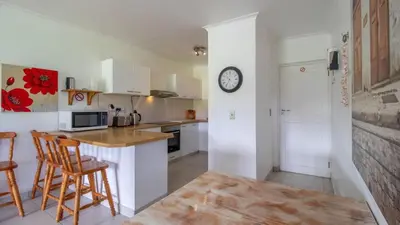 a kitchen with a counter and a clock on the wall at Greenways Strand Golf Beach C3 in Strand