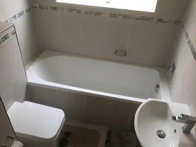 a bathroom with a tub and a toilet and a sink at Greenways Strand Golf Beach C3 in Strand