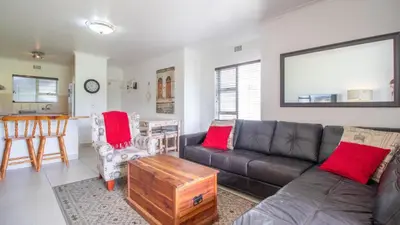 a living room with a couch and a table at Greenways Strand Golf Beach C3 in Strand