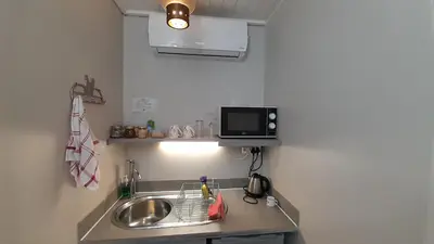 a kitchen with a sink and a microwave at Vergenoegd Guesthouse in Panorama