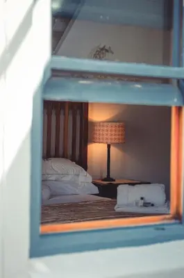 a view of a bedroom with a bed and a lamp at Hemel en Aarde cottages in Hermanus