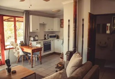a kitchen with a couch and a table in a room at Hemel en Aarde cottages in Hermanus