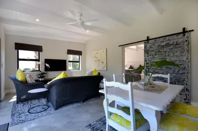 a living room with a couch and a table at SAFFRON COTTAGE in Hermanus