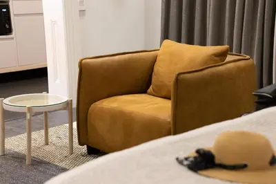 a brown chair sitting next to a bed at Heritage House in Stellenbosch