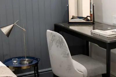 a bedroom with a desk with a chair and a lamp at Heritage House in Stellenbosch