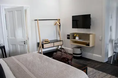 a bedroom with a bed and a flat screen tv at Heritage House in Stellenbosch