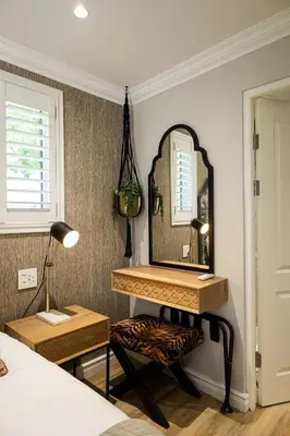 a bedroom with a dressing table and a mirror at Cape Village Lodge in Durbanville