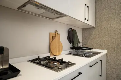 a kitchen with a stove and a counter top at Cape Village Lodge in Durbanville