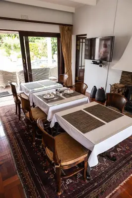 a dining room with a table and some chairs at Cape Village Lodge in Durbanville