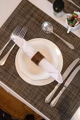 a napkin on a plate with fork and knife at Cape Village Lodge in Durbanville