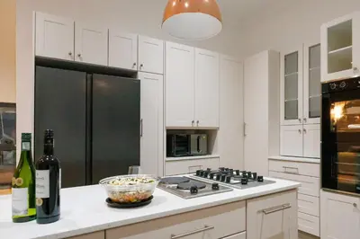 a kitchen with white cabinets and a black refrigerator at De Hoop Farm - Mountain View in Breerivier