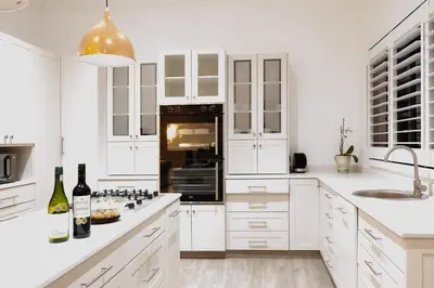 a white kitchen with white cabinets and a black appliance at De Hoop Farm - Mountain View in Breerivier