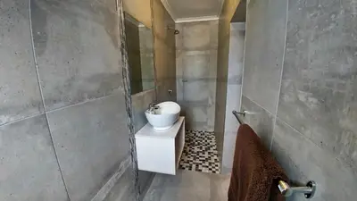 a bathroom with a sink and a mirror at Blouberg Beach Retreat in Bloubergstrand