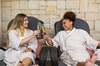 two women are holding glasses of white wine at Santé Wellness Retreat & Spa in Paarl