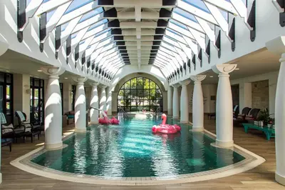an indoor swimming pool with pink inflatables in a building at Santé Wellness Retreat & Spa in Paarl