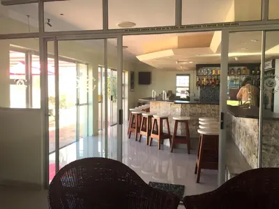 a kitchen with a bar with chairs and tables at 176 hbc in Hermanus