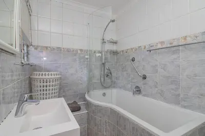a bathroom with a sink and a bath tub at 176 hbc in Hermanus