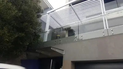 a building with a glass door and a balcony at GORDON's SHORE LUXURY APARTMENTS - Solar Powered in Gordonʼs Bay