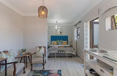 a bedroom with a bed and a sink in a room at Petite Apartment in Bellville
