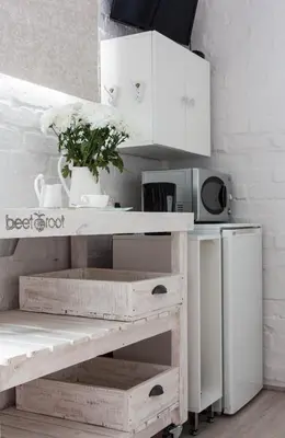 a white kitchen with a table and a microwave at Petite Apartment in Bellville
