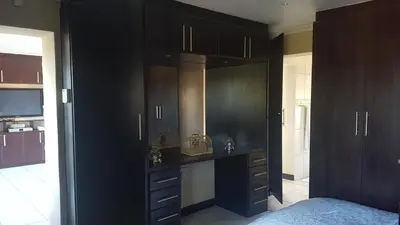 a bedroom with black cabinets and a bed in it at Alyssa's Inn Boutique Guesthouse in Cape Town