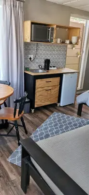 a room with a kitchen and a bed and a table at Tranquility in Parow