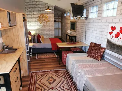 a small room with a bed and a kitchen at Tranquility in Parow