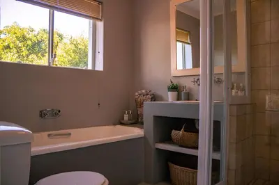 a bathroom with a tub and a toilet and a sink at Hermanus Family Getaway - Near The Beach in Hermanus