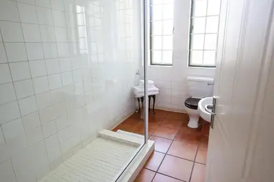 a bathroom with a shower with a toilet and a sink at The Habit Guesthouse in Worcester
