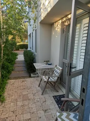a patio with a table and a chair on a house at Nerf-af ROOMS at Onrus , Hermanus in Hermanus