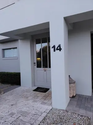 a white house with a door with the number at Nerf-af ROOMS at Onrus , Hermanus in Hermanus