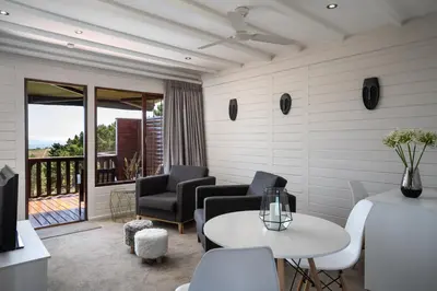 a living room with two chairs and a table at Lalapanzi Lodge in Somerset West