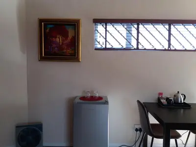 a room with a refrigerator and a table and a window at Flamingo Palms in Table View
