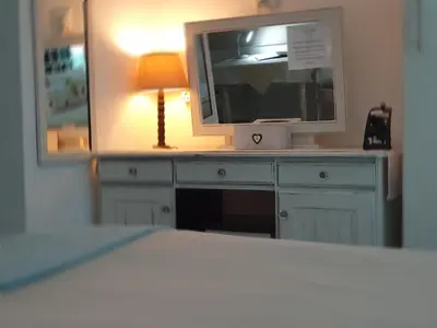 a television sitting on top of a dresser with a lamp at Tyger Hills Guest House in Bellville