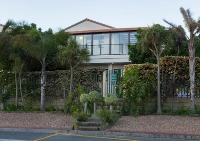 a house with palm trees in front of it at Tyger Hills Guest House in Bellville