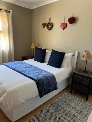 a bedroom with a bed with blue pillows and hearts on the wall at 3 on Nebraska Accommodation in Bellville