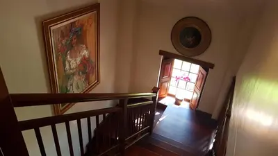 a stairway with a painting on the wall and a door at Vredenburg Manor House in Somerset West