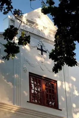 a white building with a window and a cross on it at Vredenburg Manor House in Somerset West