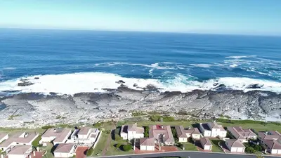 an aerial view of a beach with houses and the ocean at 123 hbc in Hermanus
