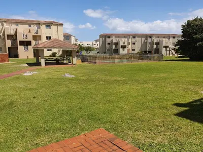 a park with a gazebo in front of a building at 123 hbc in Hermanus