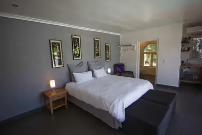 a bedroom with a large white bed and a table at Panorama Indlu in Cape Town