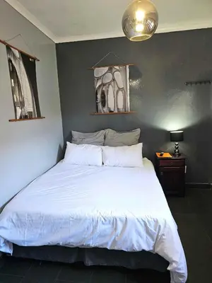 a bedroom with a large white bed in it at Panorama Indlu in Cape Town