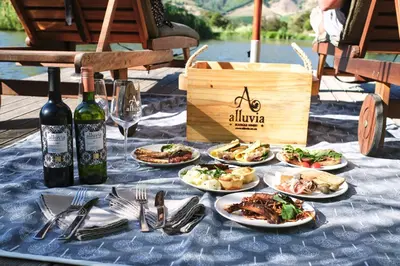 a table with plates of food and bottles of wine at Alluvia Boutique Winery & Luxury Accommodation in Stellenbosch