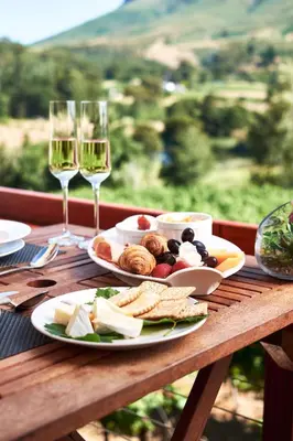 a table with plates of food and glasses of wine at Alluvia Boutique Winery & Luxury Accommodation in Stellenbosch