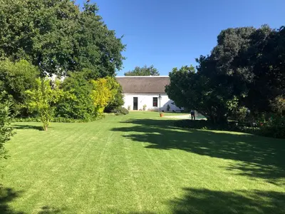 a large yard with a white house and trees at Becketts Bliss in Worcester