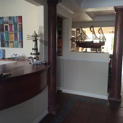 a room with a counter and a window with a boat in it at Birkenhead Manor in Bloubergstrand