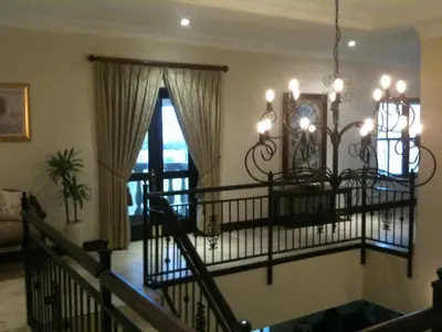 a living room with a chandelier and a staircase at Roman Retreat in Cape Town