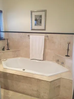 a large bath tub in a bathroom with a towel at Roman Retreat in Cape Town