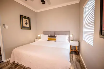 a bedroom with a large white bed and a window at The Corner House L'A-nnexe in Franschhoek