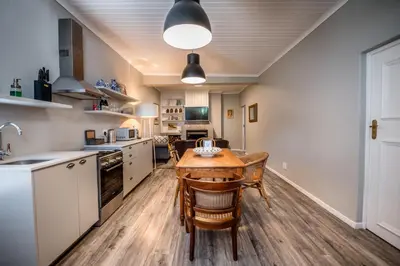 a large kitchen with a wooden table and chairs at The Corner House L'A-nnexe in Franschhoek